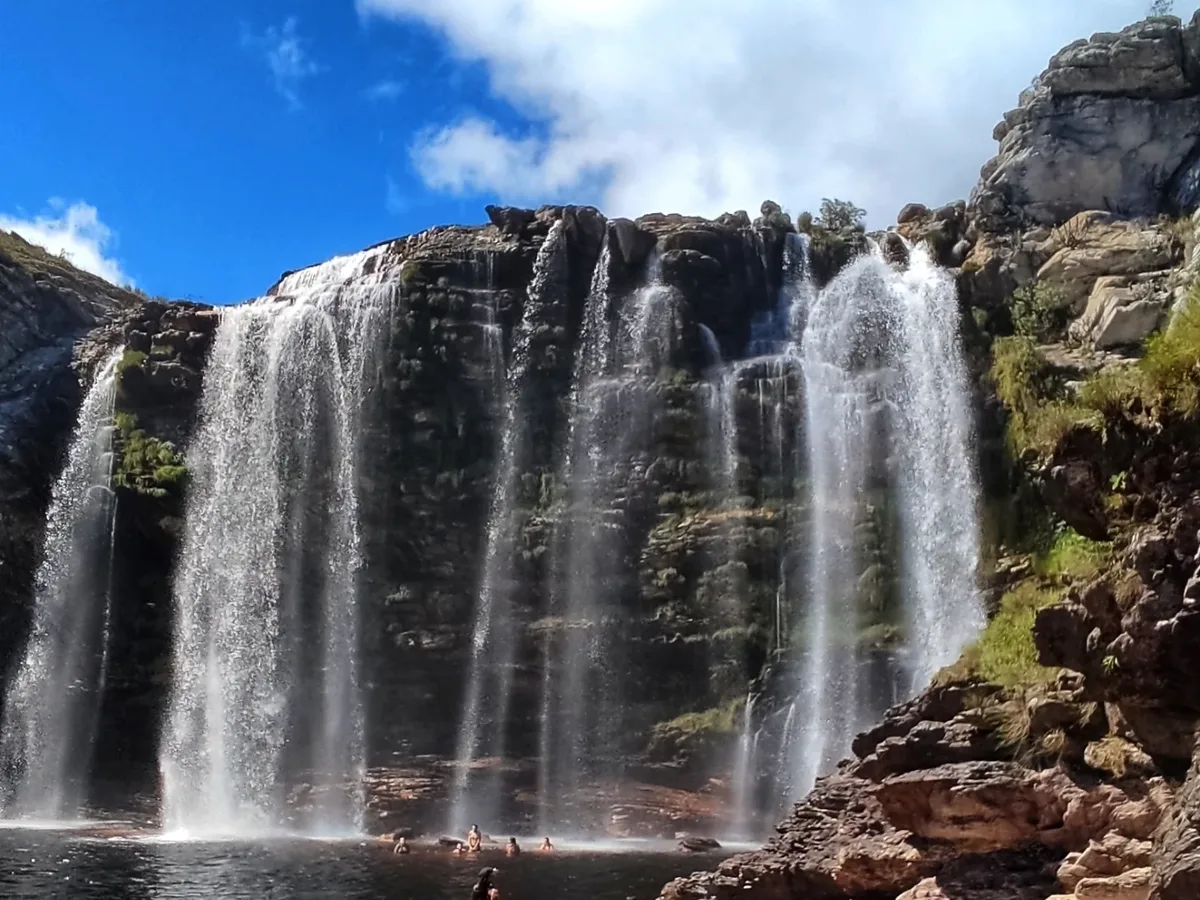Cachoeira na Serra do Espinhaço próxima a Lapinha da Serra, com visitantes se banhando na piscina natural